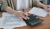 Hands of a female therapist using a calculator while calculating her tax write-offs for therapists