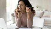A therapist sits holding her cellphone to her ear listening to hipaa compliant voicemail script