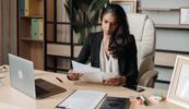 A therapist sits at her desk and reviews a HIPAA breach notification letter that she wrote.