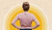 A woman standing with her hands on her hips in front of a yellow collage.