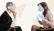 Two women sit facing each other. One has her hand on her chin and is leaning forward, and the other is gesturing.