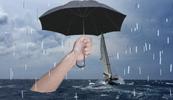 A collage of a hand holding an umbrella in a stormy sea.