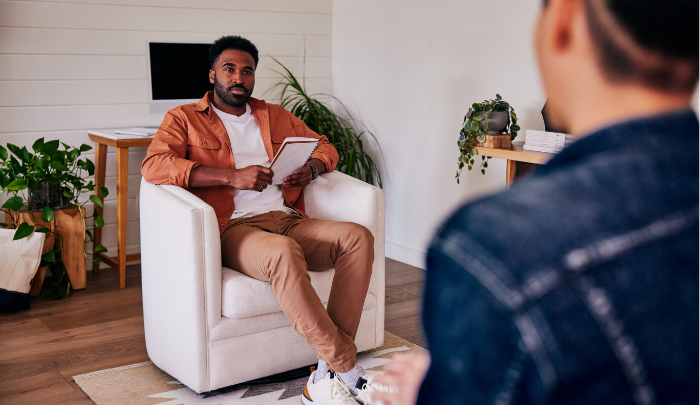 Male counselor discussess counseling confidentiality with a client during a session