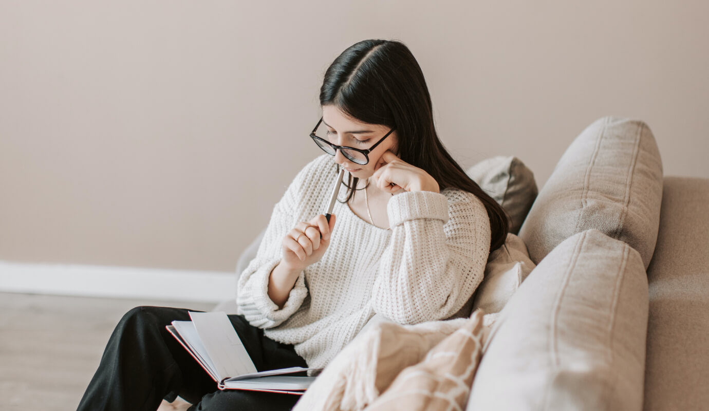 A clinician sits down with her notebook to try writing the Objective in SOAP notes she has to complete.