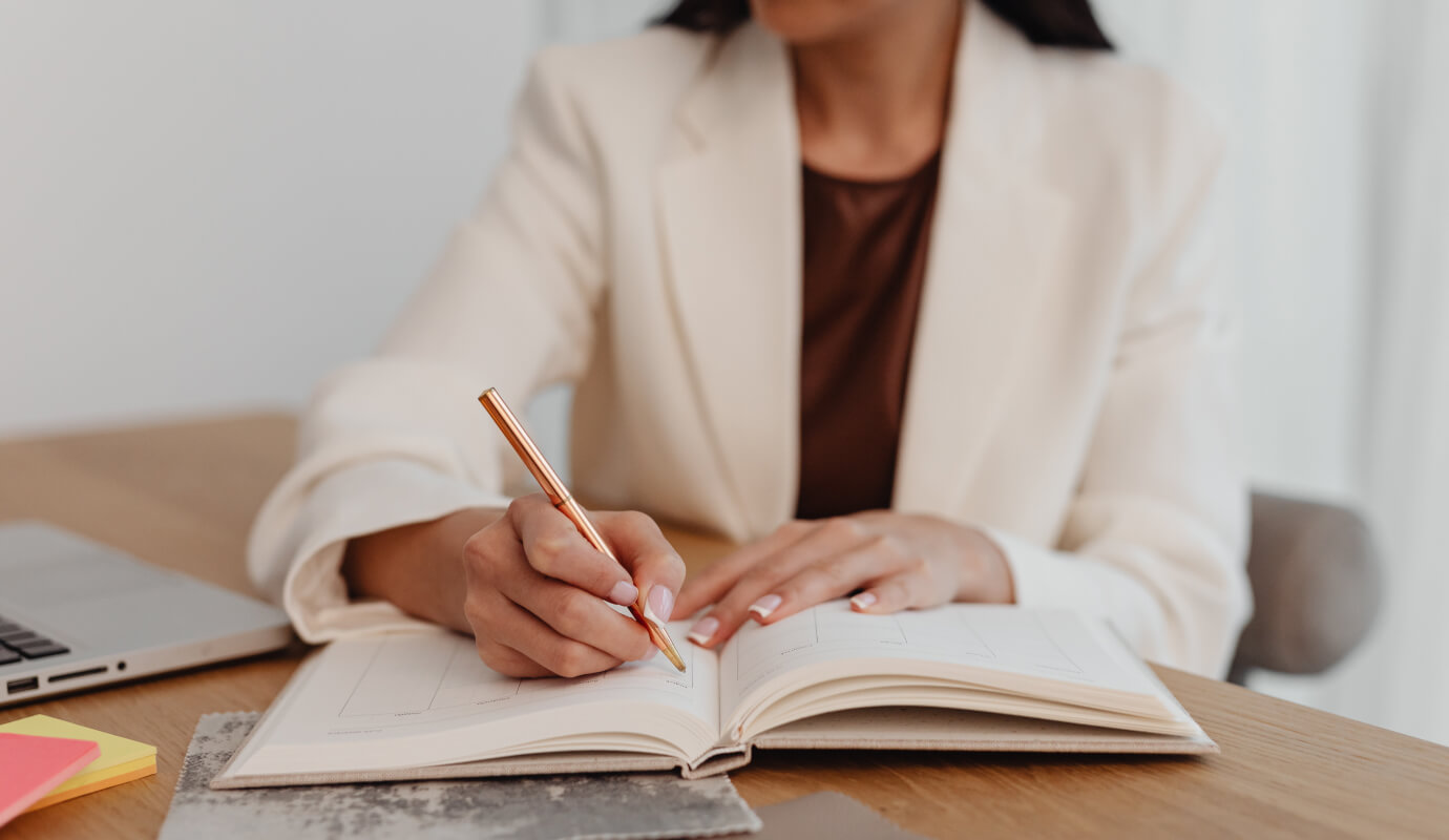 A female therapist writes out the SOAP note assessment section in her notebook