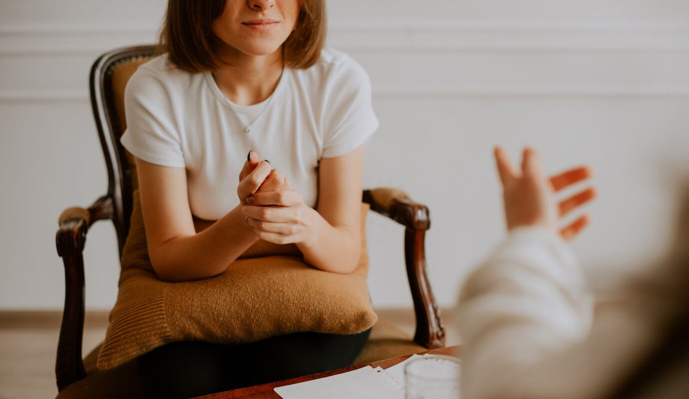 A female counselor explains to a client scenarios that require breaches of client confidentiality