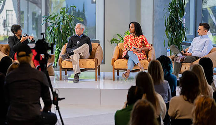 A panel of two women and two men are in conversation on a stage in front of an audience about the state of mental health in America at SimplePractice headquarters in California