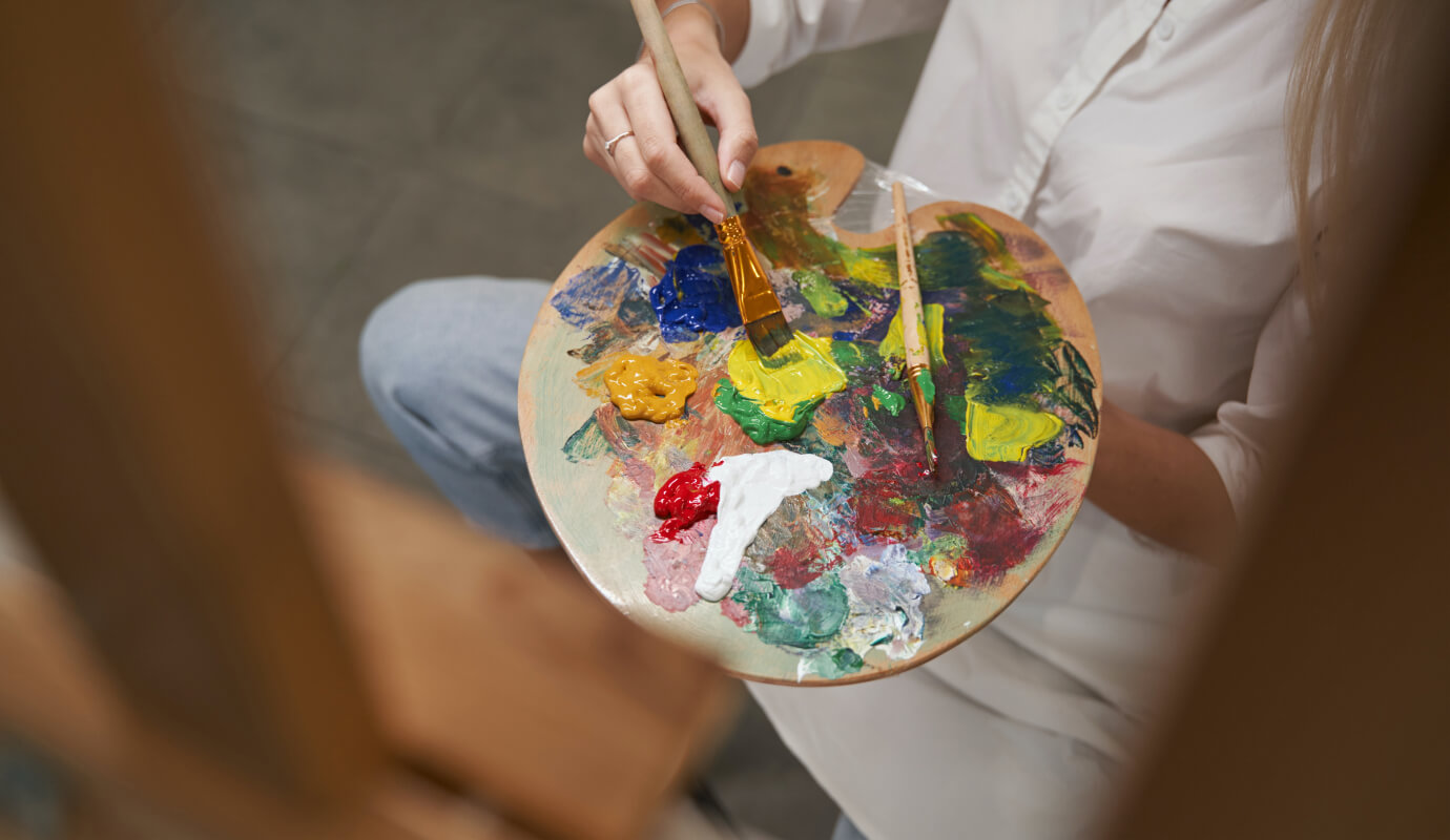 A female therapy client does art therapy activities which include painting with a variety of colors