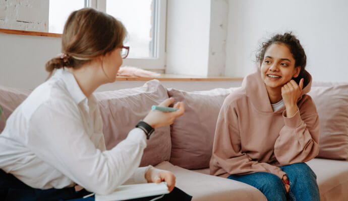 A female therapist conducts a psychotherapy session with a female client sitting on a couch, psychotherapy is one of the top CPT codes of 2022