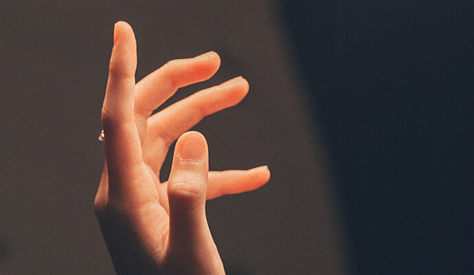 A hand in front of a dark background