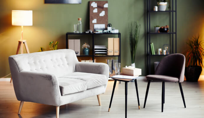 A grey couch, chair, and table in a therapy office showing good examples of therapist office design