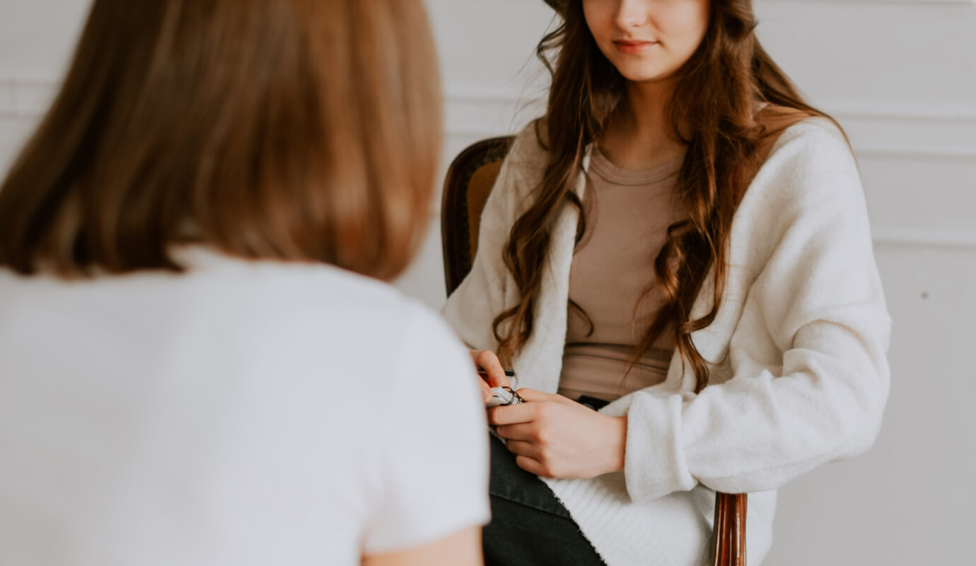 A therapist sits down with her client as she conducts a neurofeedback session.